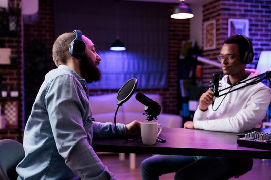 Two men interviewing for a podcast in a studio.